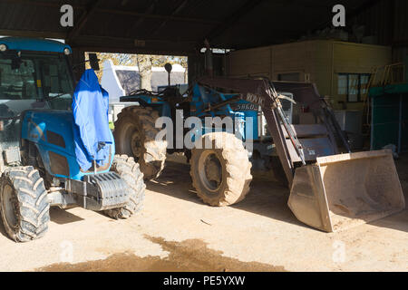 Les tracteurs de ferme stationné à l'intérieur dans un hangar sur un domaine viticole à Cape Town Banque D'Images