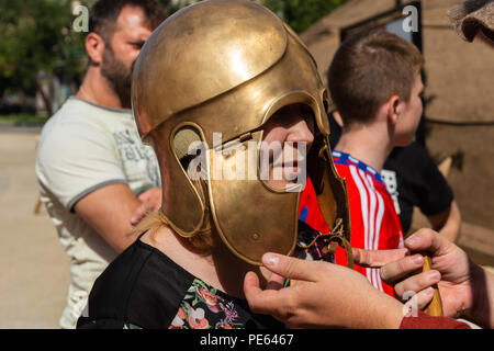 Moscou, Russie, dimanche 12 août, 2018.Le huit histoire internationale festival 'Times' époques & commence à Moscou. La période d'exposition est août 10-22. Le lieu de la fête est boulevard Ring (9 km ou 6 km de long). Les périodes historiques et les événements de l'âge de pierre à la fin du XX siècle sont présentés par des équipes internationales dans 30 endroits. Femme non identifiée'tente sur un ancien casque militaire grec. Ancien Grèce période. Crédit : Alex's Pictures/Alamy Live News Banque D'Images