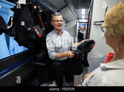 Hambourg, Allemagne. Août 13, 2018. Chauffeur de bus Andreas Hinze obtient une paire de shorts de mise en place de Christine Augustin, de vêtements (ÉSAP Hochbahn), dans les vêtements de l'bus Hochbahn. La chaleur de l'été a un impact sur le code vestimentaire pour Hambourg, bus et train conducteurs, qui sont en ce moment de porter autour de 1000 court-circuit d'un pantalon noir. Crédit : Christian Charisius/dpa/Alamy Live News Banque D'Images