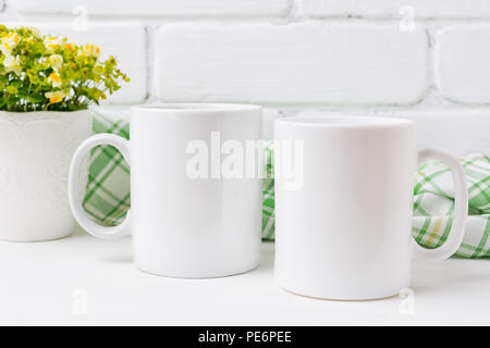 Deux tasse à café blanc avec de petites maquettes jaune et vert de fleurs. Tasse vide pour la conception des maquettes de promotion. Banque D'Images