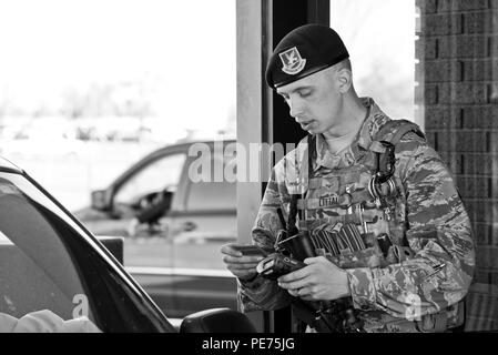 Navigant de première classe Kaleb Littau, 5e Escadron des Forces de sécurité l'entrée de l'installation, le contrôleur vérifie l'identification d'autoriser l'entrée à Minot Air Force Base, N.D., Octobre 14, 2015. Le s.. Alfredo Garza, Senior Airman Curtis Sey et Littau, forces de sécurité 5ème vol Alpha, les contrôleurs d'entrée installation ouverte la porte principale de 6 h à 18 h, contrôle de l'identification et l'inspection des véhicules. (U.S. Air Force photo/Navigant de première classe J. T. Armstrong) Banque D'Images