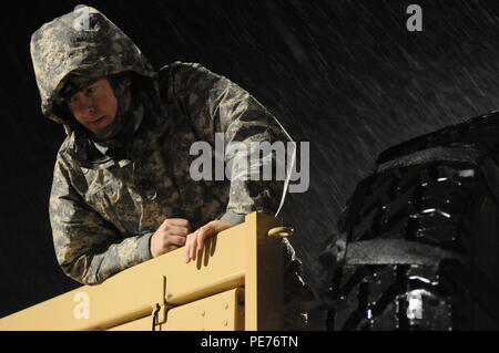 Le s.. Kevin L. Frawley, un chef d'équipe dans la Garde nationale du Texas 236e compagnie du génie, guides membres de son équipe dans le changement d'un pneu sur un véhicule tout terrain léger moyen en vue de mener des opérations de sauvetage d'inondation dans la région de Huntsville, Texas, le 24 octobre 2015. Les membres de la 236e compagnie du génie, une partie du 111e bataillon du génie, se sont mobilisés pour Corsicana et Baie-Comeau, au Texas, pour se tenir prêt à répondre à n'importe quel sauvetage doit causé par la pluie torrentielle résultant de l'Ouragan Patricia en octobre 2015. (U.S. La Garde nationale de l'armée photo par le Sgt. Michael Giles/libérés) Banque D'Images