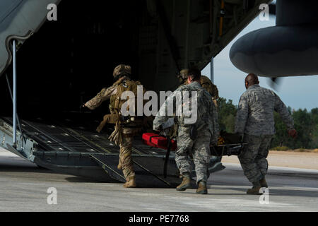 Quatre aviateurs du 347e Groupe de sauvetage transportent un pilote de l'armée de l'air portugaise à bord d'un C-130J Hercules pendant une formation de sauvetage près de la base aérienne de Beja, au Portugal, le 23 octobre 2015. Cette opération, menée pendant Trident Juncture 2015, a impliqué plus de 35 000 membres du personnel des pays de l’OTAN et de ses partenaires, mettant l’accent sur le sauvetage aérien, la coordination entre les équipages aériens et le personnel au sol, l’interopérabilité et l’état de préparation opérationnelle des forces alliées. Banque D'Images