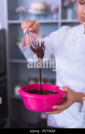 Le boulanger avec nail art blanc gâteau au chocolat de cuisson Banque D'Images