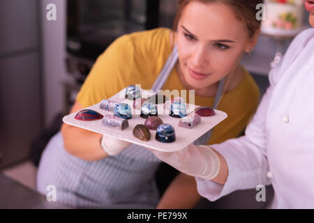 Beautiful housewife examinant des chocolats assortis Banque D'Images