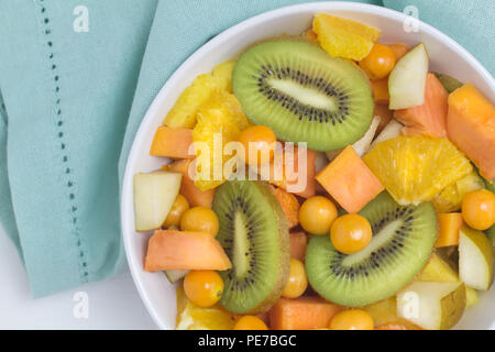 Salade de fruits - Top view photo de divers fruits, kiwi, ananas, papaye, poire groseille et d'orange dans un bol close up Banque D'Images