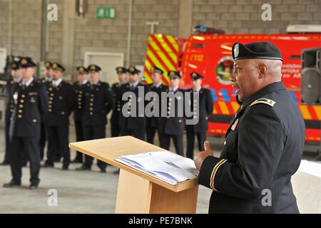 Le lieutenant-colonel Sandy Sadler, sortant 773e de l'aide aux civils, commandant de l'équipe parle au cours de la 773e cérémonie de passation de commandement, le 30 octobre 2015, à Halle, en Belgique. Les pompiers belges à partir de la zone Hulpverlenings tribune Ouest Brabant en formation dans l'arrière-plan. (Photo par le sergent. Rick Scavetta, 7e l'appui aux missions du Bureau des affaires publiques de commande) Banque D'Images