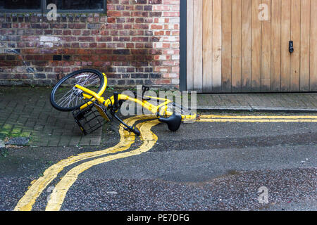 Une location partagée Ofo jaune abandonné d'une manière irréfléchie sur double lignes jaunes dans une ruelle à Islington, Londres, Royaume-Uni Banque D'Images