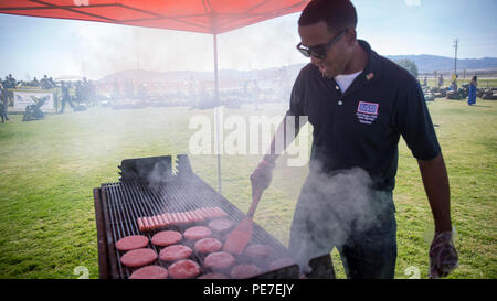 Vinniane Terrel, bénévole, ASS, grillades hamburgers et hot-dogs pour la famille et les amis de 3e Bataillon, 7e Régiment de Marines, au cours de l'unité de son déploiement au champ Del Valle, 11 octobre 2015. 'Avant-garde' déployés dans le cadre de la masse d'Air Maritime Task Force - la réponse aux crises - Commande centrale 15.2. (Marine Corps photo par Lance Cpl. Levi Schultz/libérés) Banque D'Images