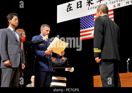 U.S. Air Force Brig. Le général Barry Cornish, 18e Escadre, lit un certificat de mention élogieuse à Mitsuo Yamaguchi, 18e Escadron de génie civil section formation incendie, adjoint au nom de la Kadena Air Base employés locaux au cours d'une durée de Service Award cérémonie à l'Okinawa Convention Center dans la ville de Ginowan, Japon, le 15 octobre 2015. Un total de 265 employés locaux de Kadena, ont reçu le Prix de la durée de service commun. (U.S. Air Force photo par Naoto Anazawa) Banque D'Images