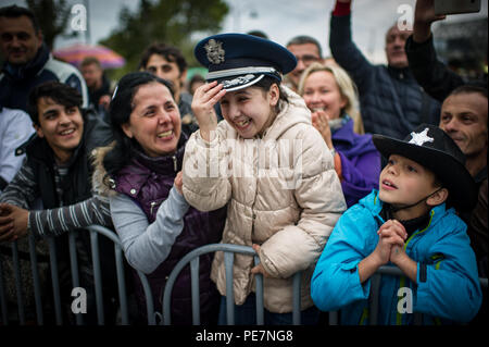 Une fille rit tout en portant une des forces aériennes américaines en Europe membre du groupe's hat pendant une fanfare show à Tbilissi, Géorgie, Octobre 17, 2015. De 15 à 19 octobre, 33 musiciens de l'US Air Forces in Europe Band s'est rendu à la République de Géorgie pour plusieurs événements, y compris l'exécution dans le premier Festival international de musiques militaires à Tbilissi. C'est la première fois en près de 10 ans que la bande USAFE a voyagé de mener une mission dans la République de Géorgie. La Géorgie et les États-Unis sont des partenaires militaires et des engagements comme ceux-ci contribuent à renforcer encore les liens entre Banque D'Images