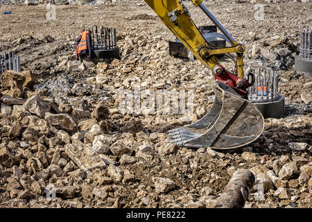 Avis d'une partie de bras de pelle hydraulique avec vérin et flexibles sur un chantier de construction. Fermer Banque D'Images