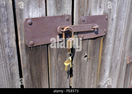 Ancienne grange sur cadenas déverrouillé gauche porte sur une exploitation agricole en Pologne Banque D'Images