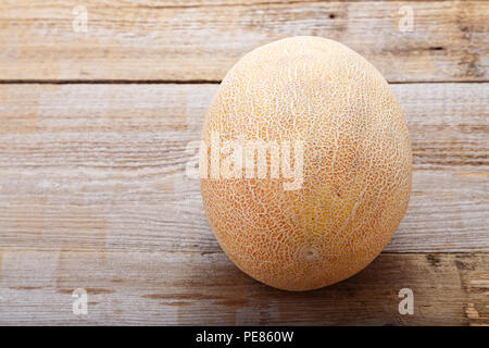 Un melon entier sur une vieille table en bois Banque D'Images