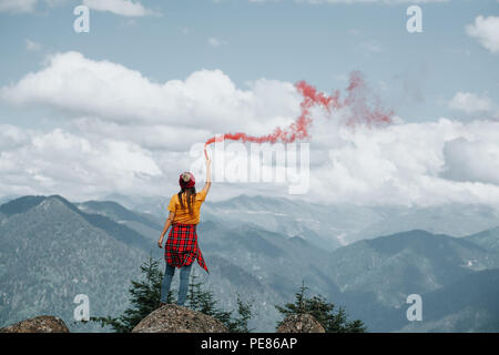 Femme sur sommet de montagne avec red flare.Inspiration concept Banque D'Images
