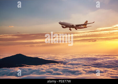 Avion dans le ciel au coucher du soleil - avion de passagers des avions. Banque D'Images