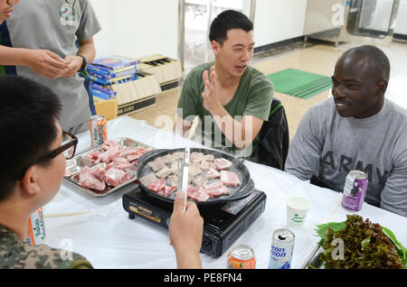 La CPS. James Huggins, ingénieur de combat de West Palm Beach, Floride, affecté à la Compagnie Bravo, 8e bataillon du génie de la Brigade Blindée, 2e Brigade Combat Team, 1re Division de cavalerie, apprend l'art du barbecue coréen de soldats de l'Armée de la République de Corée a 1-58ème bataillon du génie au cours d'un échange culturel organisé par le 1-58ème, Bucheon, Corée du Sud, le 30 septembre 2015. (U.S. Photo de l'armée par le sergent. John Healy, 2ABCT PAO, 1re Division de cavalerie) Banque D'Images