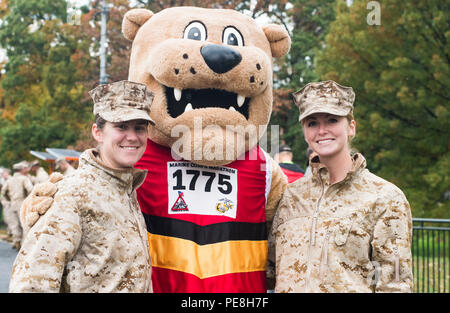 U.S. Marine Corps lieutenants de l'école de base à Quantico, en Virginie, de prendre une pause de leur travail bénévole de poser pour une photo avec Miles, l'une des mascottes de Marathon Marine Corps, lors de la 40e marathon du Marine Corps à Arlington, en Virginie, le 25 octobre 2015. Aussi connu comme 'la', Marathon la course de 26,2 km a attiré environ 30 000 participants de promouvoir la forme physique, de générer la bonne volonté dans la communauté, et de mettre en valeur les compétences organisationnelles du Marine Corps. (U.S. Marine Corps photo par le s.. Sarah R. Hickory/libérés) Banque D'Images