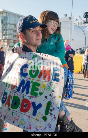 Le premier maître de John M. Mincey, un membre d'équipage à bord du garde-côte de Spencer, tient sa fille après l'outil de coupe est retourné à son port d'attache à Boston Vendredi, Octobre 30, 2015, après une patrouille de 65 jours de la mer des Caraïbes. Au cours de la patrouille, l'équipage de Spencer intercepté quatre rendez-rapide des navires soupçonnés de trafic de stupéfiants, et a directement contribué à la saisie 2 204 13 697 livres de marijuana et de cocaïne d'environ 50 millions de dollars. (U.S. Photo de la Garde côtière du Maître de 2e classe Cynthia Oldham) Banque D'Images