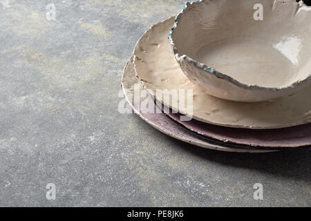 Souvenirs traditionnels faits à la main en porcelaine plaque colorée et le bol sur un fond de béton gris. Banque D'Images