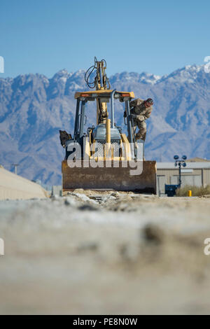 Un technicien des chaussées et de l'équipement du 455e Escadron expéditionnaire du génie civil inspecte une pelleteuse à l'aérodrome de Bagram, en Afghanistan, pour appuyer les opérations de construction et d'entretien. Le 455e ECES « Dirt Boys » prépare des zones pour le ciment dans des structures de maintenance de grande superficie, soutenant l'infrastructure de l'US Air Force, la préparation au déploiement et les projets d'ingénierie opérationnelle dans le cadre des opérations en cours à l'appui de Resolute support et de l'opération Freedom Sentinel. Banque D'Images