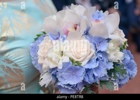 Jeune femme de race blanche ou de demoiselle portant une robe bleu d'argent avec détails et tenant un bouquet de roses, rose pâle avec amdorchids Banque D'Images