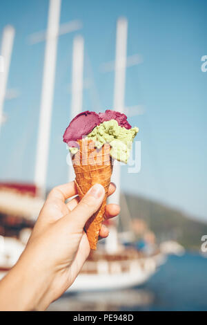 Woman's hand holding de la crème glacée aux fruits en cornet gaufré. Banque D'Images