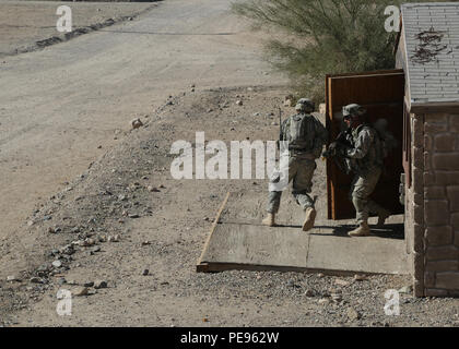 Des soldats américains affectés au 1er Bataillon, 41e Régiment d'infanterie, 2e Brigade Combat Team, 4e Division d'infanterie, d'attaque au moyen d'une ville au cours de l'action décisive 16-02 Rotation au Centre National d'entraînement à Fort Irwin, en Californie, le 12 novembre 2015. Les soldats faisaient partie d'une opération d'agresser et de saisir un ennemi bastion. (U.S. Photo de l'armée par la FPC. Daniel Parrott/libérés) Banque D'Images