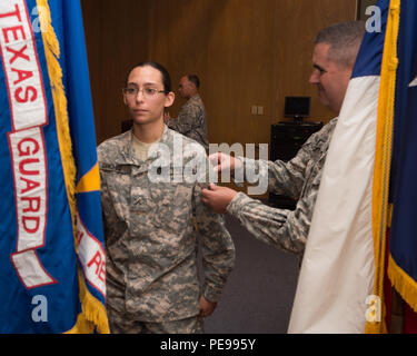 Le Colonel Robert François Paré, droite, commandant du 2e Régiment, la garde de l'État du Texas, les onglets Pvt. Angeline Sanchez avec le patch TXSG pour remplir le régiment d'orientation de base régionale à la formation d'une cérémonie tenue à Austin, Texas, le 20 septembre 2015. Agobot se tient deux fois par année dans différents domaines à travers l'état d'enseigner de nouvelles coutumes militaires, gardes les premiers soins et de RCR, percer et cérémonie, la navigation terrestre et de radio communication. La formation est divisée en deux phases au cours des exercices mensuels. (U.S. La Garde nationale de l'armée photo par le Sgt. 1re classe Malcolm McClendon) Banque D'Images