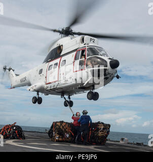 Mer de Chine du Sud, (nov. 22, 2015) - 2e classe Controlman feu Nicholas Darnell et chef de l'Artilleur 4400 Daniel Bieber un crochet de charge passe sur un hélicoptère Puma SA-330 affecté au Commandement du transport maritime militaire de cargaisons sèches/munitions ship USNS Amelia Earhart (T-AKE-6) au cours d'un remplacement verticale en mer à bord du USS Fort Worth (LCS) 3. En ce moment sur une rotation de 16 mois déploiement à l'appui de l'Asia-Pacific rééquilibrer, Fort Worth est un navire de guerre rapide et agile sur mesure pour patrouiller les eaux littorales de la région et travailler à coque coque avec des marines, partenaire fournissant 7e flotte avec les capacités flexibles il Banque D'Images