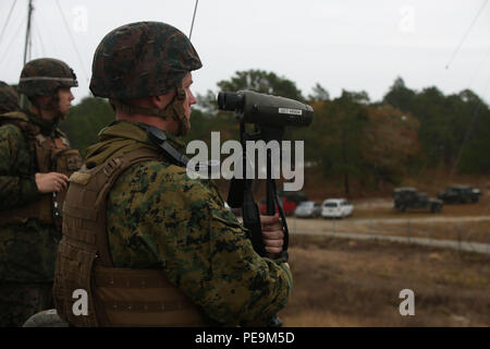 Un pompier du 1er bataillon du 10e régiment de Marines observe le tir de la ronde d'entraînement du M1122 au Camp Lejeune, en Caroline du Nord. La munition M1122 est une munition d'entraînement rentable, environ un tiers du coût des munitions d'artillerie standard, ce qui permet aux Marines de mener une formation efficace au tir réel tout en réduisant les dépenses. L'exercice met l'accent sur la maîtrise de l'artillerie, la manipulation des armes, la préparation opérationnelle et le soutien aux programmes d'entraînement de la 2e Division des Marines. Banque D'Images
