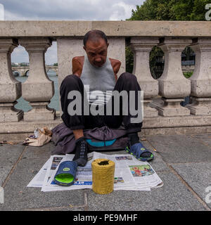 Mendiant sur un pont sur la seine, Paris, France Banque D'Images