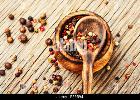 Assortiment de grains de poivre dans la boîte sur un fond de bois Banque D'Images