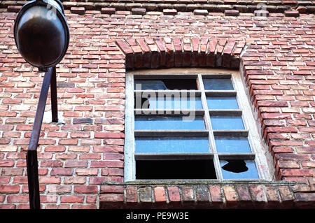 Plus de détails sur la ruine d'un bâtiment industriel en brique rouge, lampe et fenêtre avec verre cassé, abandonné et détruit des bâtiments industriels Banque D'Images