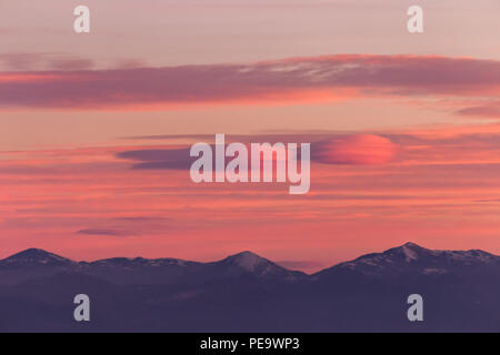Un avis de certaines montagnes haut, sous un ciel aux couleurs chaudes, magnifique au coucher du soleil Banque D'Images