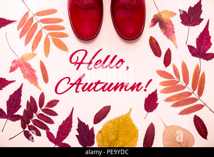 Les feuilles d'automne multicolore rouge et des bottes de caoutchouc. Bonjour, l'automne des mots. Banque D'Images