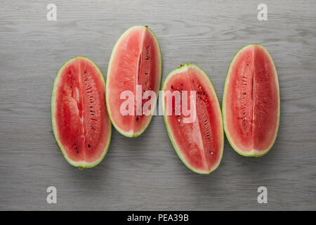 Vue de dessus les tranches de melon frais disposés sur la surface en bois gris Banque D'Images