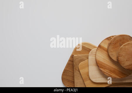 Vue du dessus de la pile de planches à découper en bois différents sur tableau blanc Banque D'Images