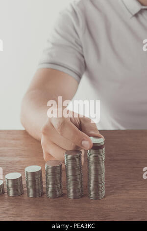 Portrait de l'homme l'empilage de pièces sur une table en bois, concept d'économie Banque D'Images