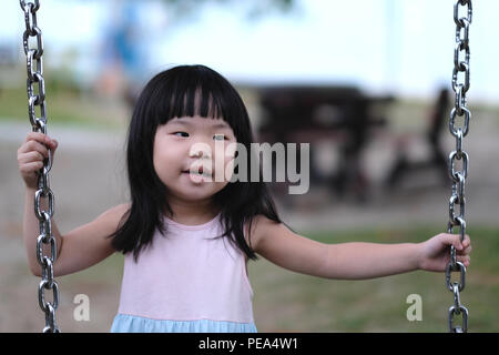 Portrait d'une petite asian girl in swing Banque D'Images