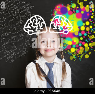 La créativité de l'éducation. Enfant intelligent little girl smiling on school tableau arrière-plan. Le développement, l'art et la science, hémisphères droit et gauche de la Banque D'Images