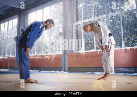 Deux combattants judo ou message d'athlètes dans un arc avant de pratiquer les arts martiaux dans un fight club. Mettre en place les deux hommes en uniforme. Lutte, karaté, de la formation, de l'art, l'athlète, la concurrence concept Banque D'Images