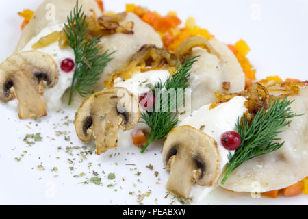 La cuisine russe traditionnelle Knedlík ou vareniki, pâte de viande ou d'autres farces, avec de la farine et des oeufs servis sur une table avec de la crème, les champignons et les légumes frais, sauce à l'ail. Meubles anciens traditionnels servant à la faïence. Sait aussi que des pelmeni et Smetana Banque D'Images