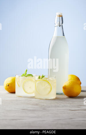 Bouteille et verres de limoncello italien frais sur table en bois Banque D'Images