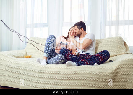 Couple playing video game assis sur un canapé dans la chambre. Banque D'Images