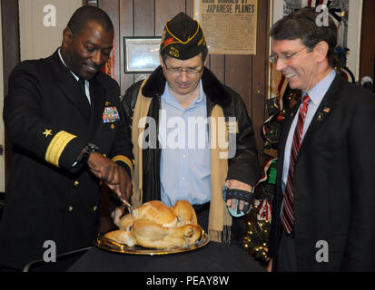 ARLINGTON Heights, Illinois (nov. 26, 2015) - Arrière Adm. Stephen C. Evans, commandant de la Marine, le commandement de l'instruction (NSTC), sculpte une Turquie comme l'Illinois Sen. Mark Kirk et Arlington Heights Maire Tom Hayes lors d'une fête de célébration à l'American Legion Post 208 ici, le 26 novembre. La Légion a accueilli Evans, Kirk, Hayes et 84 recrute dans le cadre d'un rapport annuel d'adoption d'un programme marin. Le programme permet aux organisations locales de l'Illinois, du Wisconsin et l'Indiana, comme Arlington's American Legion, d'adopter les recrues de la Marine canadienne est que boot camp, Commande d'entraînement des recrues (RTC) dans les Grands Lacs, je Banque D'Images