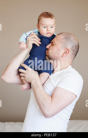 Portrait de l'âge moyen woman in white t-shirt, holding newborn baby son on shoulders tickling, se blottissant contre lui faisant rire, drôle de toucher r Banque D'Images