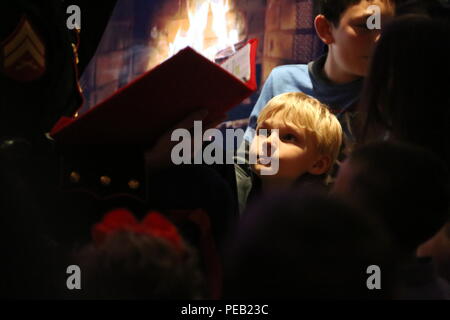 Les enfants se réunissent pour entendre les membres de la 2e bande Marine Aircraft Wing réciter une histoire de Noël au cours de l'Assemblée concert de Noël à Marine Corps Air Station Cherry Point, N.C., 4 décembre 2015. Les membres de l'auditoire et de rires partagés cheers avec d'autres membres de la communauté mais également de l'occasion pour faire un don à la fondation Toys for Tots. La 2ème bande MAW a eu lieu le traditionnel concert à la station de l'air comme un moyen d'apporter à la fois l'armée et la communauté pour se détendre et partager dans l'esprit des fêtes. (U.S. Marine Corps photo par le Cpl. N.W. Huertas/libérés) Banque D'Images