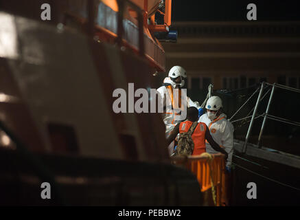 Malaga, Espagne. Août 14, 2018. Un migrant, qui a été sauvé d'un canot à la mer Méditerranée, discute avec les travailleurs de sauvetage après son arrivée au Port de Malaga. Les membres de la sécurité maritime espagnol a sauvé un total de 207 migrants à bord de quatre bateaux pneumatiques à partir de la mer d'Alboran et portées à Malaga port, où ils étaient assistés par la Croix Rouge Espagnole. Credit : Jésus Merida/SOPA Images/ZUMA/Alamy Fil Live News Banque D'Images