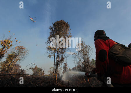 L'Indonésie, Riau, Kampar. 13Th Aug 2018. Un attentat à l'eau et les pompiers d'hélicoptères pulvériser de l'eau sur la superficie forestière brûlée de Kampar dans la province de Riau, l'Indonésie, le 13 août 2018. Les incendies de forêt et de plantation sur l'île indonésienne de Sumatra a été causé par la saison sèche. Credit : Mohammad Adam/Alamy Live News Banque D'Images